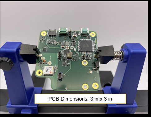 SIDEARM Iridium communicator PCB held in a bench vise